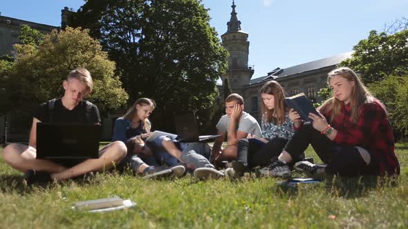 Young Exhausted Students Learning on Campus Lawn