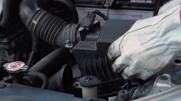 Car mechanic checking air filter, Auto mechanic working on car engine in mechanics garage