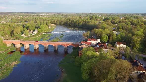 Aerial Shot Flying Towards of the Old Brick Bridge Across the Venta River in Kuldiga, Latvia