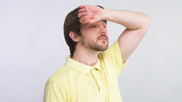 Bearded Man in Yellow Shirt Touching His Forehead To Check Body Temperature While Virus