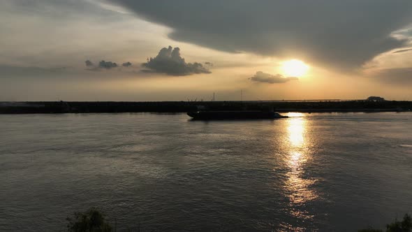 Aerial approach towards a working barge at sunset