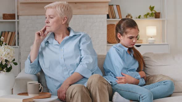 Upset Old Grandmother and Unhappy Offended Granddaughter Sit on Sofa Not Talking Having Two