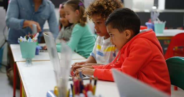 Side view of Mixed-race schoolboys studying on laptop in the classroom 4k