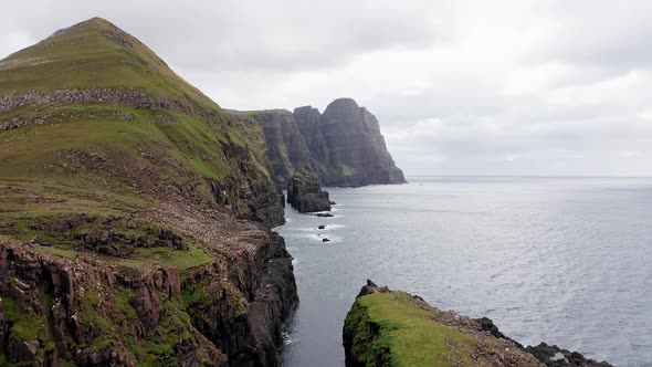 Aerial Back View of Huge Cliffs in Faroe Islands Green Rocky Mountainpowerful Ocean Wavesin a Cloudy