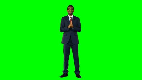 Businessman standing and smiling against green background