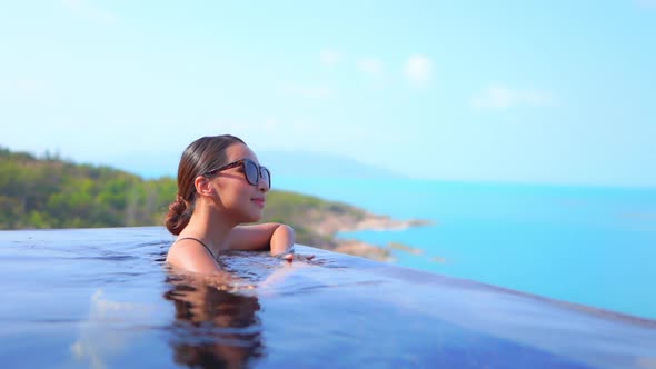 Young asian woman enjoy around outdoor swimming pool for leisure