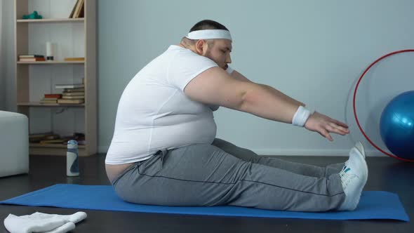 Obese Male Stretching on Mat After Home Workout, Muscle Tone, Body Flexibility
