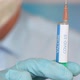 Close up of a researcher with face mask holding a syringe with coronavirus vaccine - VideoHive Item for Sale