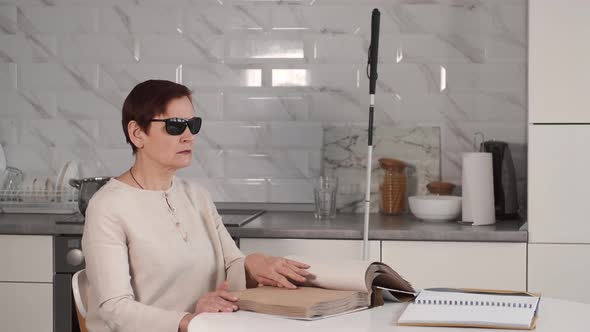 Blind Mature Woman Reading Braille Book at Home