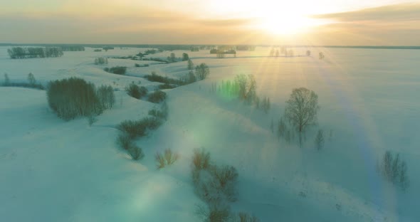 Aerial View of Cold Arctic Field Landscape Trees with Frost Snow Ice River and Sun Rays Over Horizon