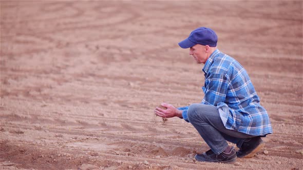 Farmer Examining Organic Soil in Hands, Farmer Touching Dirt in Agriculture Field