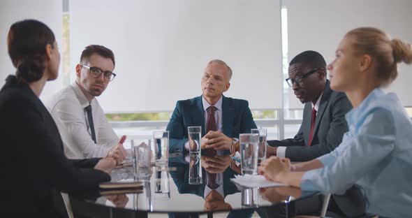 Business Leader Holding Corporate Meeting with Team in Boardroom