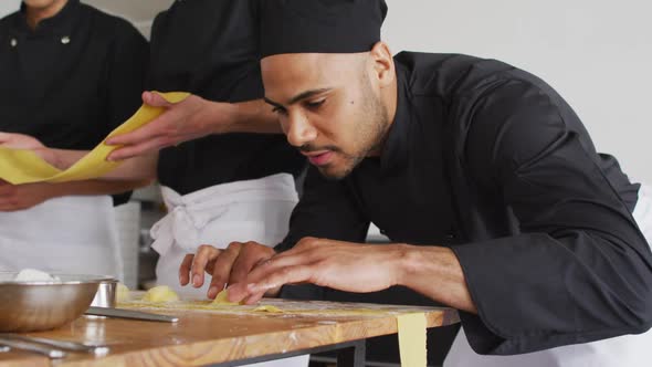 Diverse group of chefs preparing dishes and smiling in a kitchen