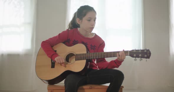 young girl playing guitar and singing