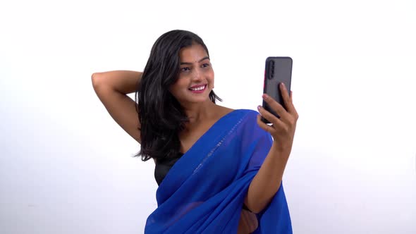 Indian woman in saree getting ready using mobile phone front camera