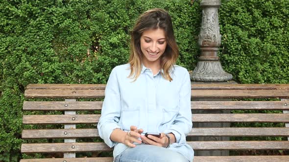 Young Woman Typing on Mobile Phone