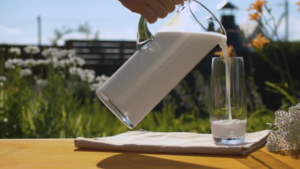 Hand pouring milk into a glass