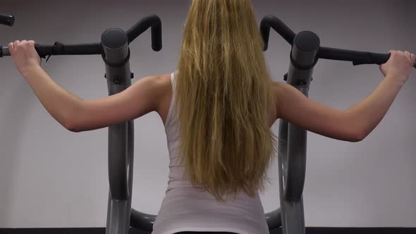 A Fit Woman Does Pull-ups in a Gym - Closeup From Behind