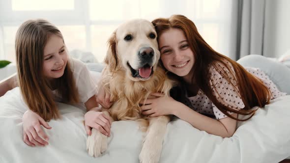 Girls with Golden Retriever Dog in the Bed