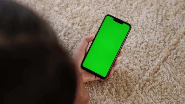 Top View Closeup View of Mobile Phone in Girls Hands with Green Mockup Screen Chroma Key Mockup or