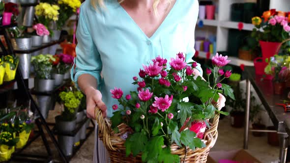 Female florist holding bunch of flowers in flower shop