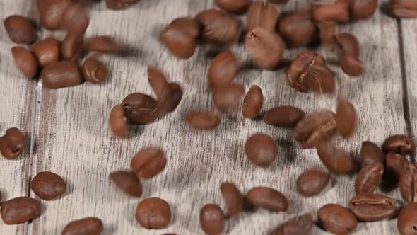 Close up coffee beans falling on wooden table