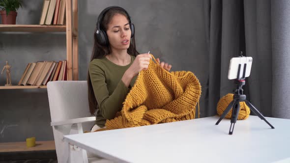 A Woman Knits While Sitting on an Armchair at Home