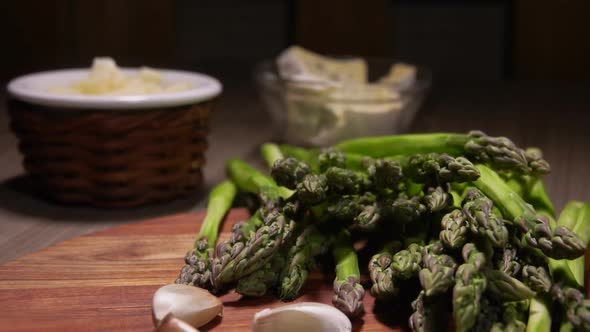 Peeled Green Asparagus Spear Laying on the Wooden Board Next To the Garlic