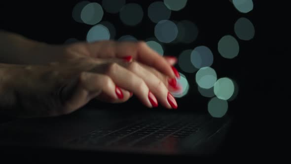 Female Hands is Typing on a Laptop at Night