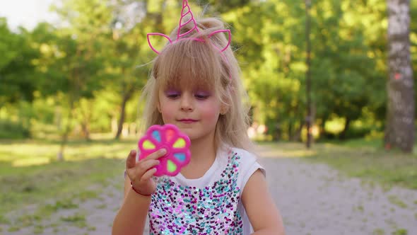 Happy Girl Playing Spinning with Pop It Sensory Antistress Toy in Park Stress Anxiety Relief