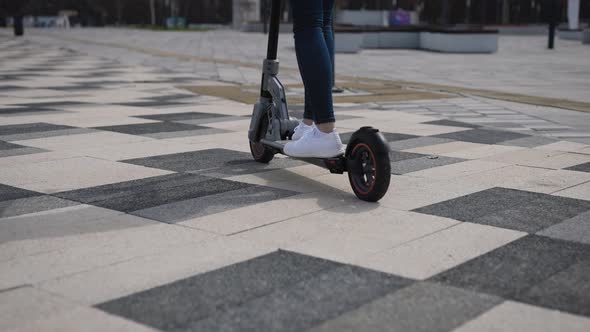 Women's Legs on an Electric Scooter