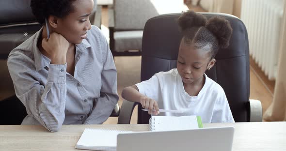 Top View Young African Mom Helping Ethnic Daughter with Homework