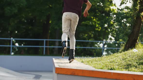 Aggressive Inline Roller Skater Doing Tricks in Concrete Skatepark Outdoors with Beautiful