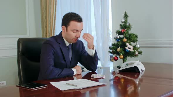 Young Businessman in a Suit Rubs His Nose, Looking Down Have No Idea and Tired