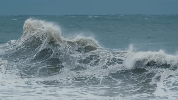 Big Wave with Foam and Dirt Breaks on the Shore During Strong Storm in the Atlantic Ocean