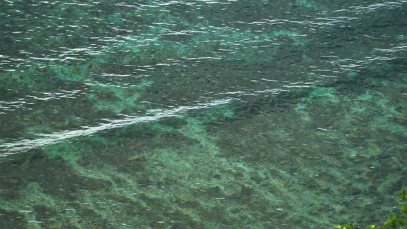 Crystal clear water is being pushed up by ocean waves reaching the shore, slowmo