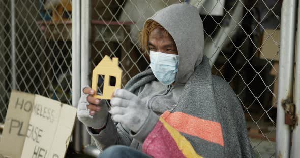 Homeless man feeling cold and holding home paper.