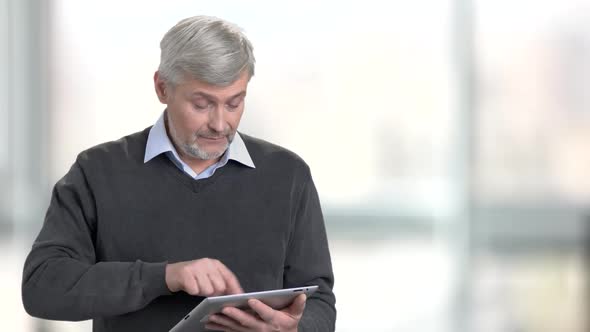 Handsome Man Using Digital Tablet on Blurred Background.