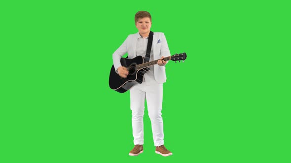 Young Man in a White Suit Playing Acoustic Guitar on a Green Screen Chroma Key