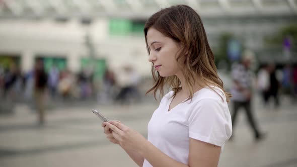 Beautiful Young Woman Using Smartphone on Street