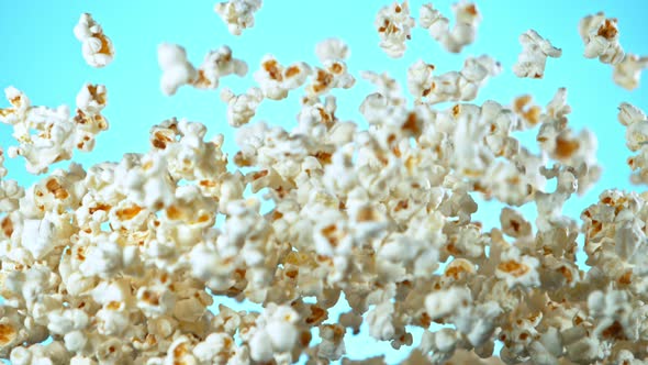 Super Slow Motion Shot of Popcorn on Blue Background After Being Exploded at 1000Fps