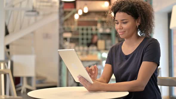 Digital Tablet Use By Beautiful Young African Woman in Cafe