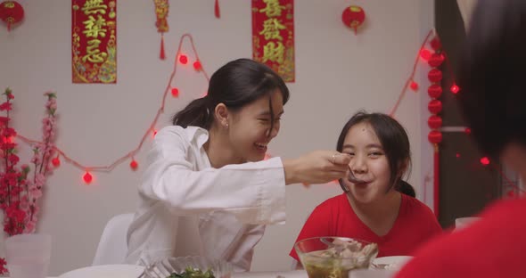 Happy Chinese Family Eating Dinner For Chinese New Year Celebrations Together At Home.