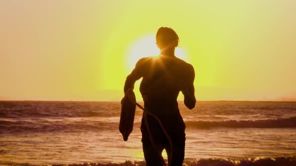 Male lifeguard running along the beach