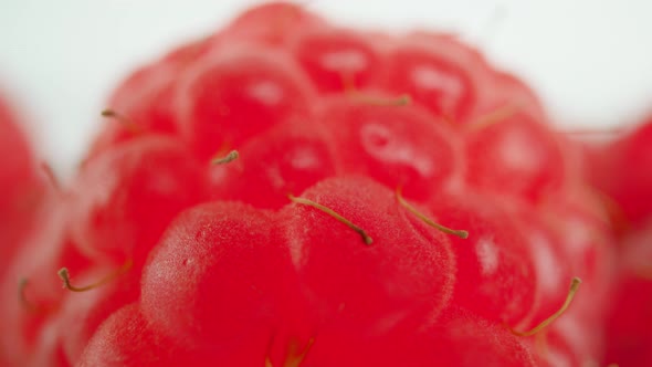 Transparent Container with Ripe Raspberries in White Studio