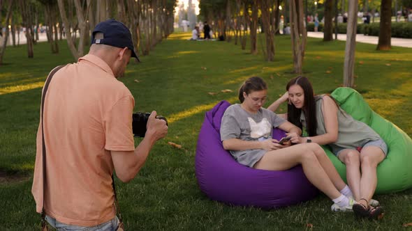 A Father Photographs His Family in a Crowded City Park in Summer