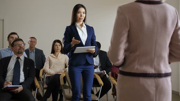 Slim Woman with Tablet Asking Speaker a Question