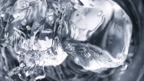 Super Slow Motion Detail Shot of Ice Cubes Falling Into Glass With Alcohol Liquid at 1000 Fps