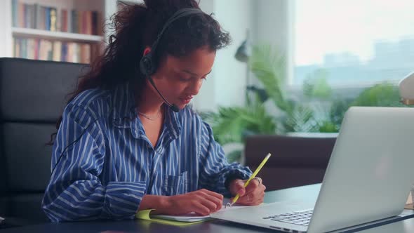 Young Indian Woman with Headset Sitting at Home Getting Education Online