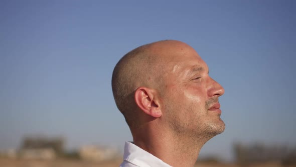 Live Camera Moves Around Face of Happy Confident Male Tourist Admiring Beauty of Picturesque Blue